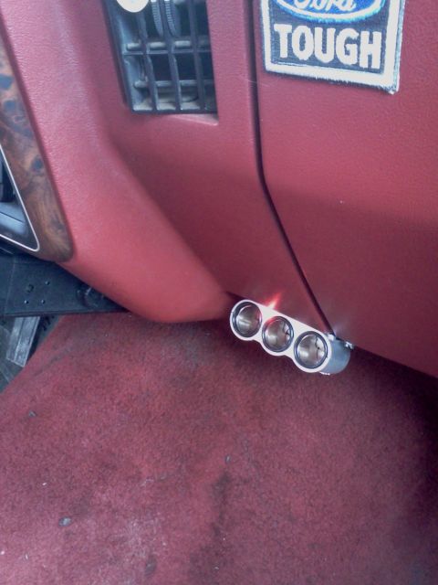 1989 Ford Bronco - A triple cigarette lighter accessory is mounted on the dashboard of a vehicle.