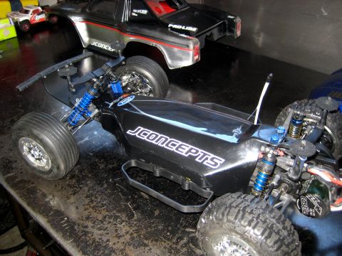 1996 Ford Bronco - Two RC car bodies and chassis are visible on a workbench.