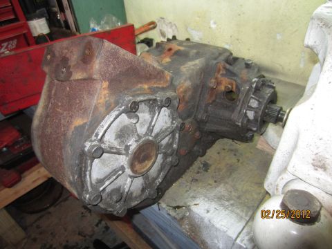 1979 Ford Bronco - This NP205 transfer case is shown on a workbench, displaying its heavily rusted exterior and mechanical components.