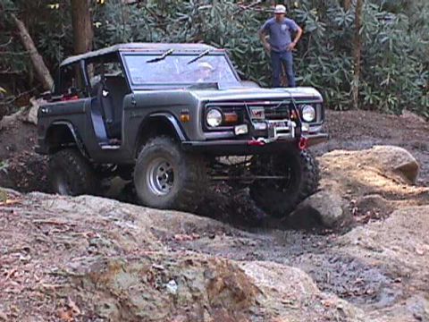 1996 Ford Bronco - A classic Ford Bronco tackles a challenging off-road trail, demonstrating its capabilities.