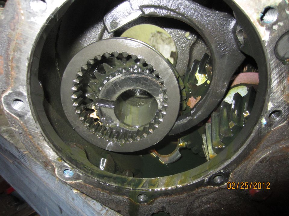 Gears and splined collar inside a greasy transmission or differential housing.