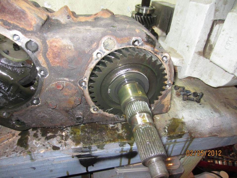 Rusty transfer case with a large gear and splined shaft.