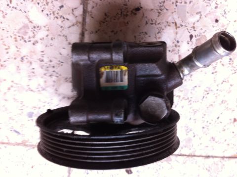 1998 Ford Crown Victoria - This is a power steering pump with its pulley attached. A yellow label with a barcode is affixed to the pump body.