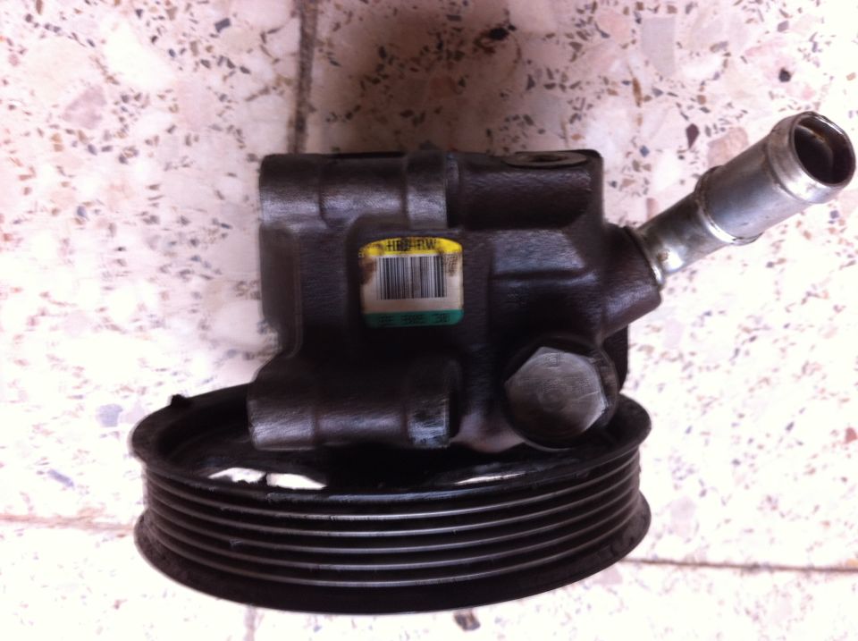 Power steering pump with pulley and a yellow label with a barcode