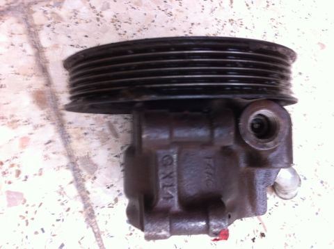 1998 Ford Crown Victoria - A close-up view of a power steering pump, showing its pulley and housing with some visible markings.