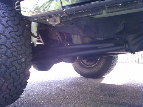 1993 Ford Bronco - The underside of a vehicle shows its suspension and drivetrain components.
