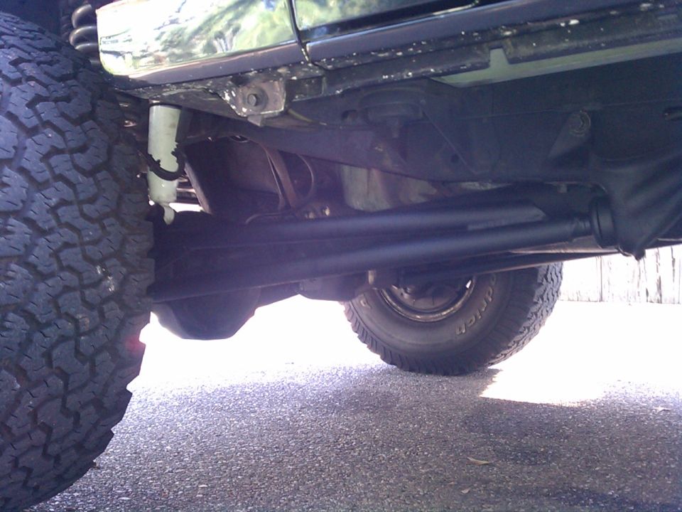 Undercarriage of a dark-colored SUV with large tires and visible suspension components