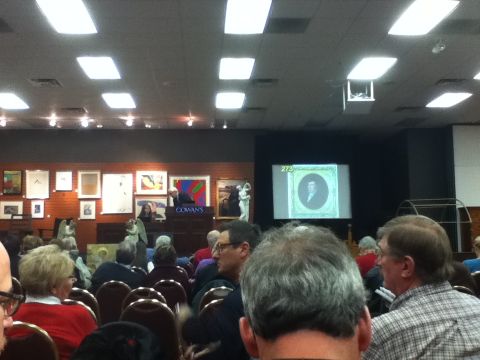 2006 Ford E350 - An auction is underway with attendees observing the proceedings and artwork displayed.