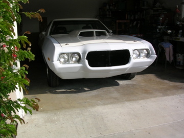 1972 Ford Ranchero - This white pickup truck, likely from the 1970s, is shown from the front with a prominent hood scoop.