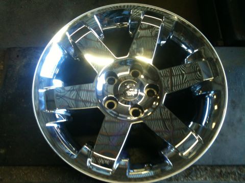 2000 Jeep TJ - A shiny chrome wheel with a distinctive five-spoke design is shown up close.