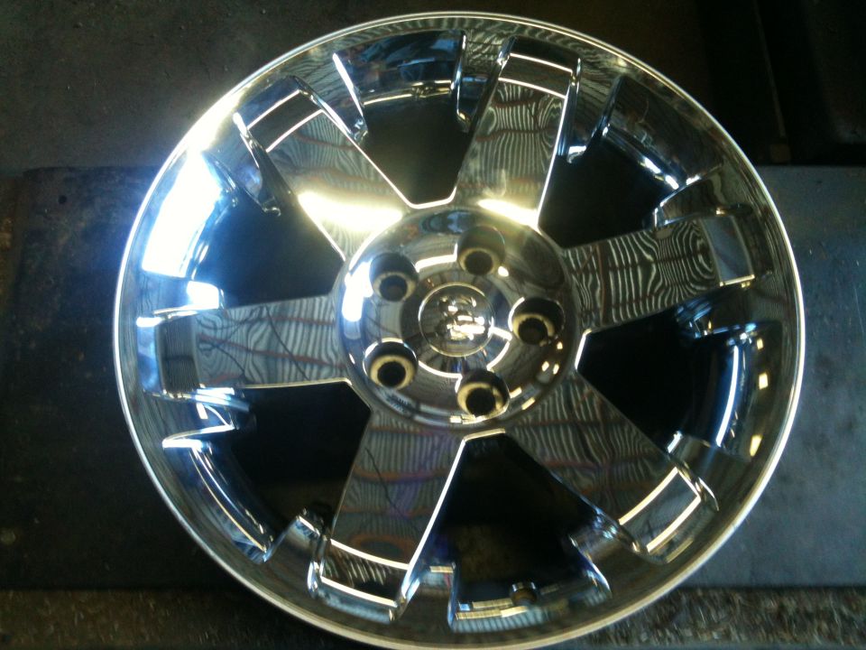 Chrome wheel with five split spokes and a center cap with a ram logo