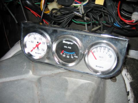 1992 Ford Bronco - A set of aftermarket gauges, including temperature, oil pressure, and voltage, are installed in the vehicle's dashboard.