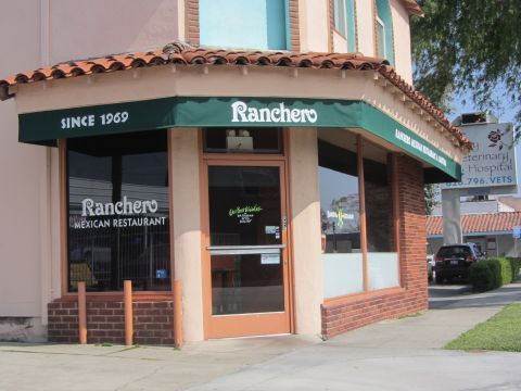 1964 Ford Ranchero - The storefront of Ranchero Mexican Restaurant, established in 1969, is visible with a green awning and large windows.