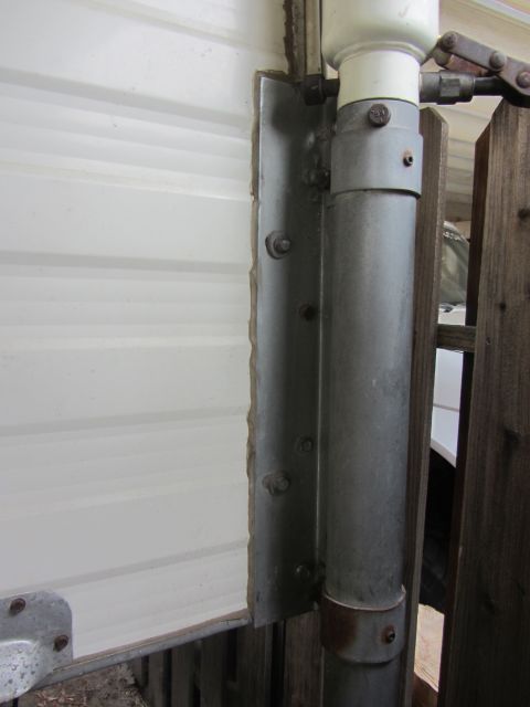 1986 Yugo GV - Detail of a garage door hinge and track mechanism, showing metal components and fasteners.