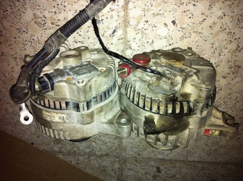 1998 Ford Crown Victoria - Two automotive alternators are shown, one with a visible part number label.