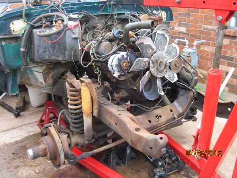 1979 Ford Bronco - The vehicle's engine and front end are disassembled and suspended by an engine hoist.