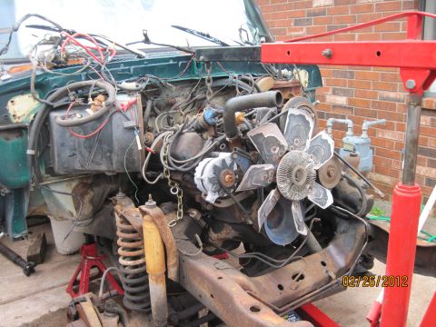 1979 Ford Bronco - The engine and front chassis of a green 1979 Ford Bronco are disassembled and supported by jack stands.