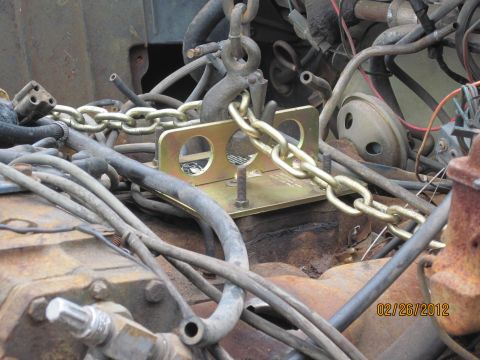 1979 Ford Bronco - Engine hoist chain and bracket assembly over rusty engine parts. Date stamp visible.