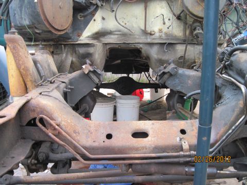 1979 Ford Bronco - Close-up of heavily rusted vehicle frame and suspension parts, likely undergoing restoration or disassembly.