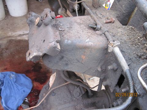 1979 Ford Bronco - A greasy steering gearbox assembly is shown, with some red fluid and a blue cloth visible on the ground.