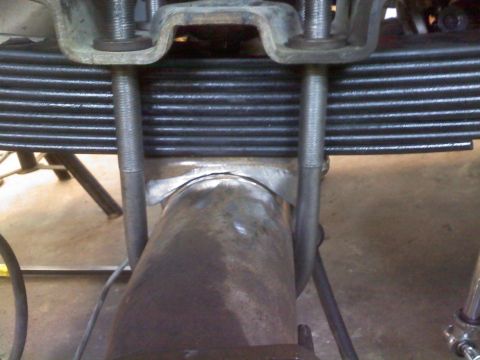 1996 Ford Bronco - Close-up view of a vehicle's rear suspension components, including leaf springs and U-bolts.