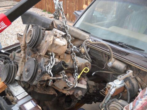 1992 Ford Explorer - Engine removal in progress, showing the complex mechanical components and chains used for lifting.
