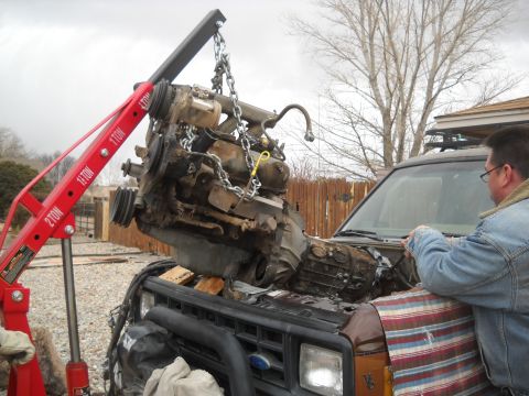 1992 Ford Explorer - Engine hoist lifting the engine out of a 1992 Ford Explorer during a repair or part removal.