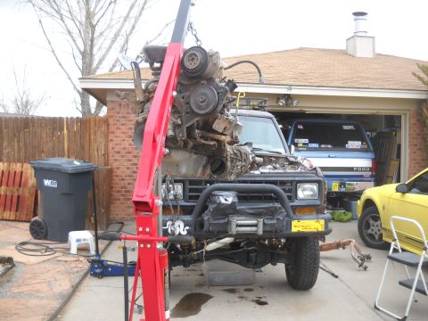 1992 Ford Explorer - Engine removal in progress on a 1992 Ford Explorer, with other vehicles visible.