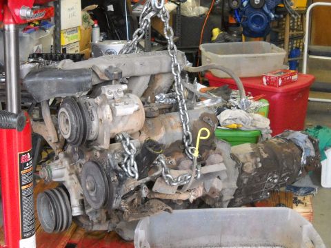 1992 Ford Explorer - This engine and transmission assembly is suspended by chains, ready for installation or removal.