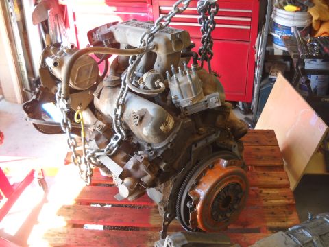1992 Ford Explorer - An engine is suspended by chains over wooden pallets in a garage setting.