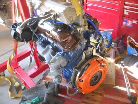 1992 Ford Explorer - Engine assembly with orange clutch housing, on a red engine stand, with tools nearby.