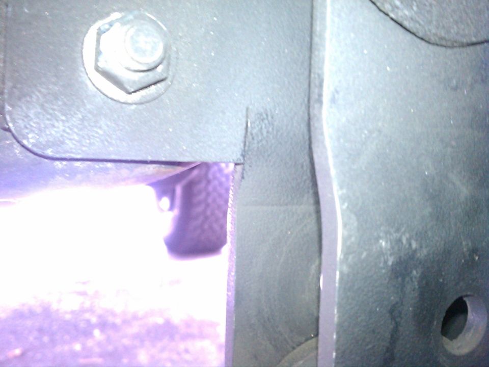 Close-up of vehicle frame with a tire visible through an opening