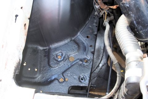 1976 Ford Ranchero - Close-up view of an engine bay component, black painted metal and a ribbed hose, with no visible year identification.