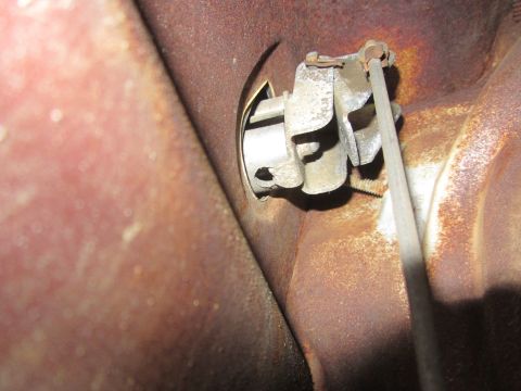 1964 Ford Ranchero - Detail of a corroded door lock actuator and cable, likely from an older vehicle.