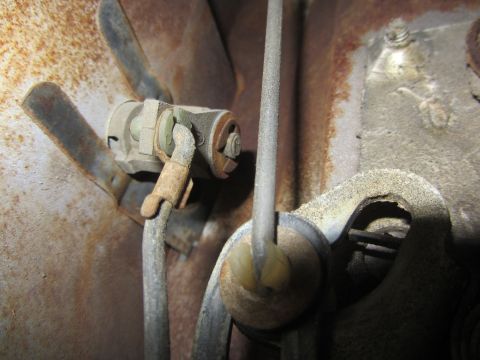 1964 Ford Ranchero - Close-up view of a vehicle's door lock mechanism, showing aged metal components and cables.