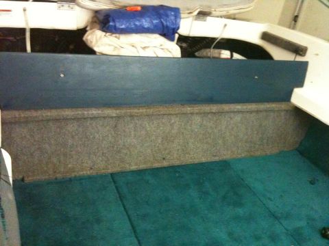 1978 Chevrolet Camaro - The interior of a boat is shown, teal carpeting and a blue tarp covering items in the back.