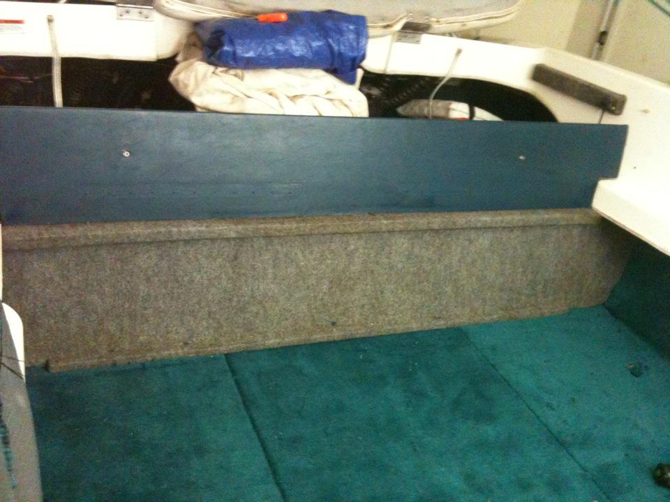 Boat interior with teal carpet and blue tarp