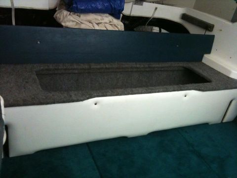 1978 Chevrolet Camaro - Interior view of boat seating with storage compartment and blue carpet.