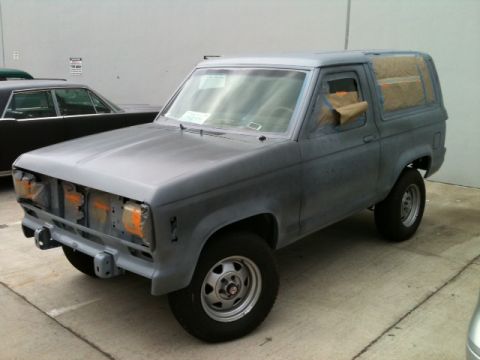 1988 Ford Bronco II - This gray SUV appears to be undergoing repairs or a repaint, with its front end partially dismantled.