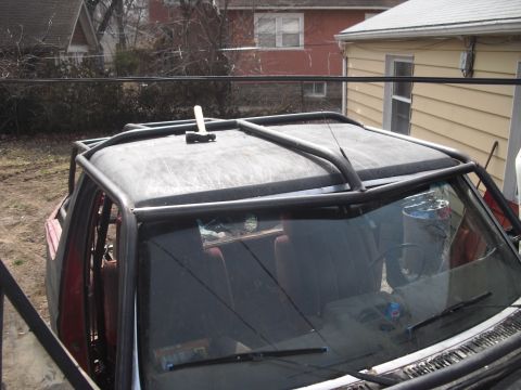 1986 Ford Bronco - Custom roll cage installed on an off-road vehicle, with a hammer resting on the roof.