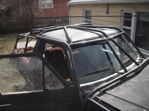 1986 Ford Bronco - This heavily modified Ford Bronco features an extensive roll cage and appears to be an older model.