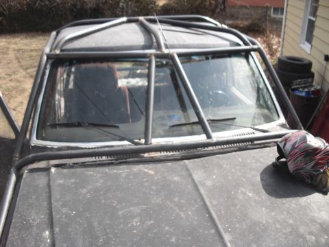 1986 Ford Bronco - Close-up view of a vehicle's front end, dominated by an external roll cage structure.