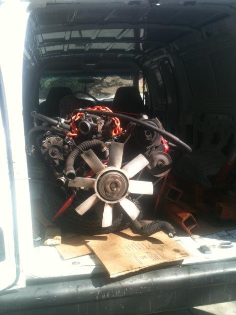 1988 Ford Bronco II - Engine and fan assembly are loaded into the back of a white van.