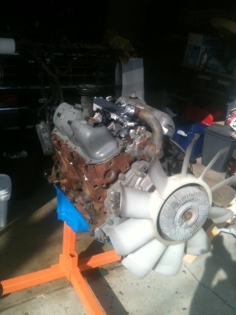 1988 Ford Bronco II - Engine assembly on an orange stand, with a large fan attached to the front.