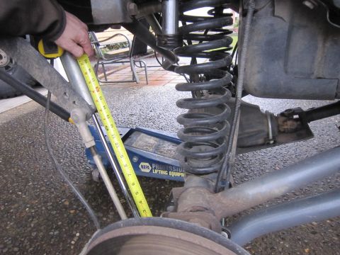 2008 Jeep Wrangler - Close-up view of a vehicle's rear suspension components being measured.