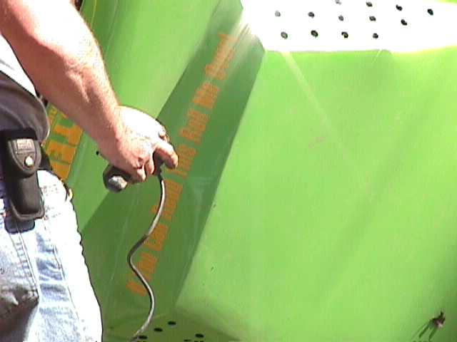 Green vehicle side with orange text and a person holding a cable