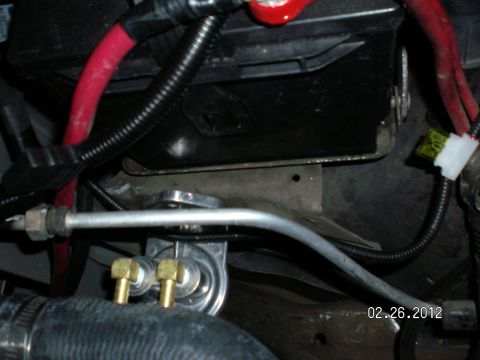 1996 Ford Bronco - A close-up view of an automotive fuel filter assembly with brass fittings and associated hoses.