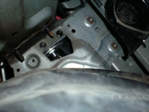 1996 Ford Bronco - A close-up view of a metal bracket with bolts and a small silver cylinder, dated 02.26.2012.