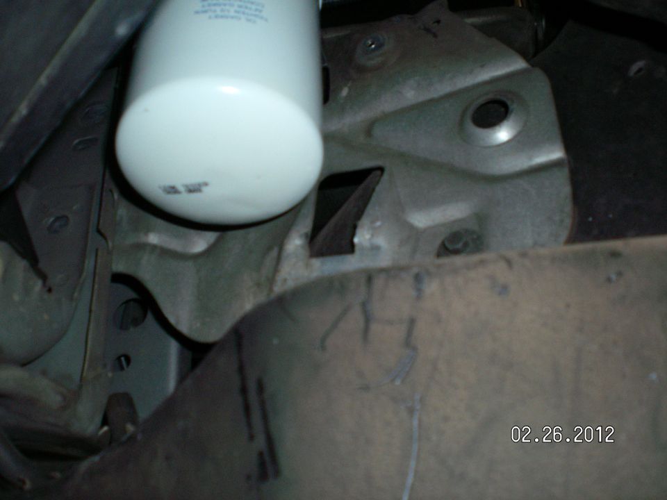 Here is the filter, mounted, and you can see to the top right, the original hole where the charcoal canister was mounted. It had  a tab at the bottom and a screw at the top...
