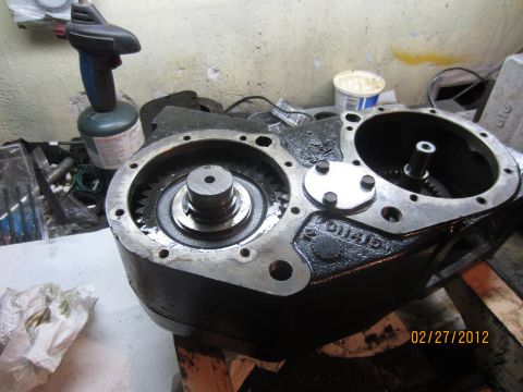 1979 Ford Bronco - A disassembled transfer case sits on a workbench, showing internal gears and components.